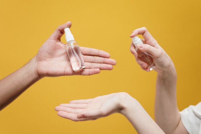 Couple of people using hand sanitizer 