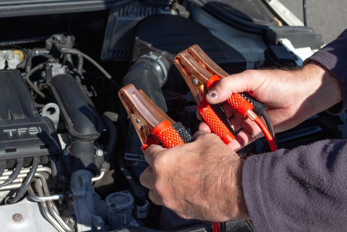 Person using Jumper cables on car 