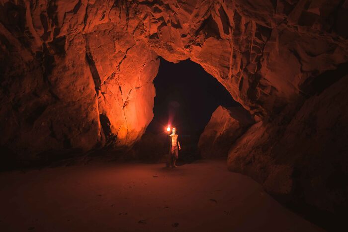 Person with a torch in a massive cave 