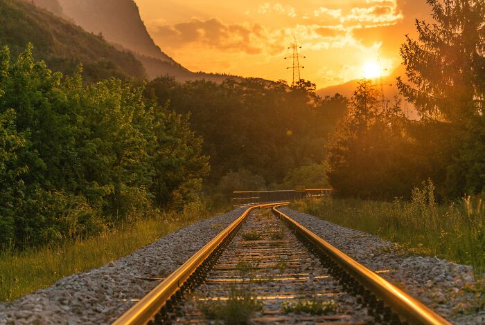 Train Rail Roads With The Sun Setting In The Background 