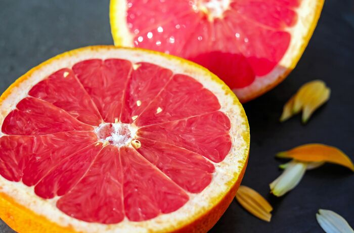 Slices of grapefruit and seeds near by 