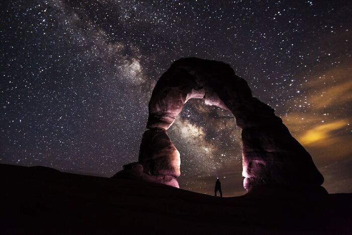 Man standing near a rock under the sky 