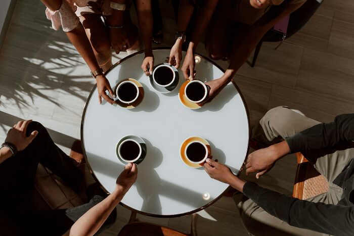 Five people drinking a cup of coffee 