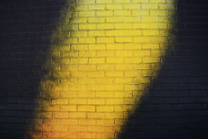 Yellow brick wall with a shadow