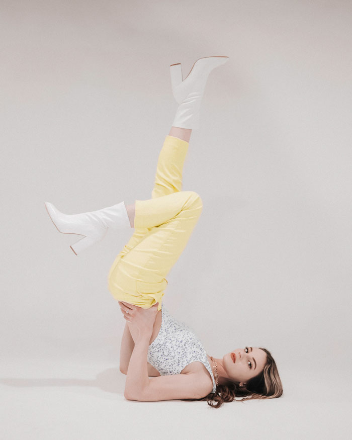 Woman wearing yellow pants and white boots