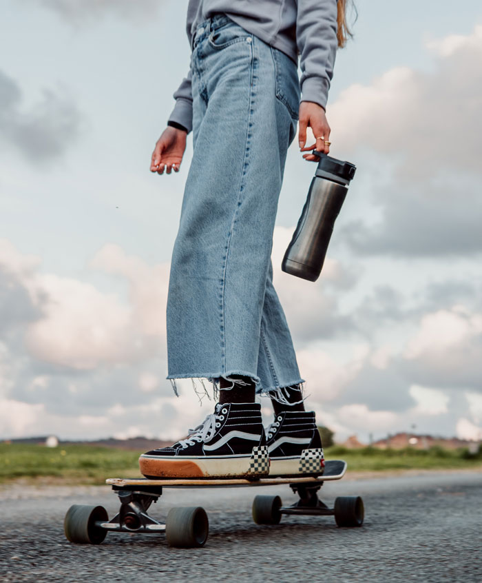 Woman wearing blue jeans and skateboarding