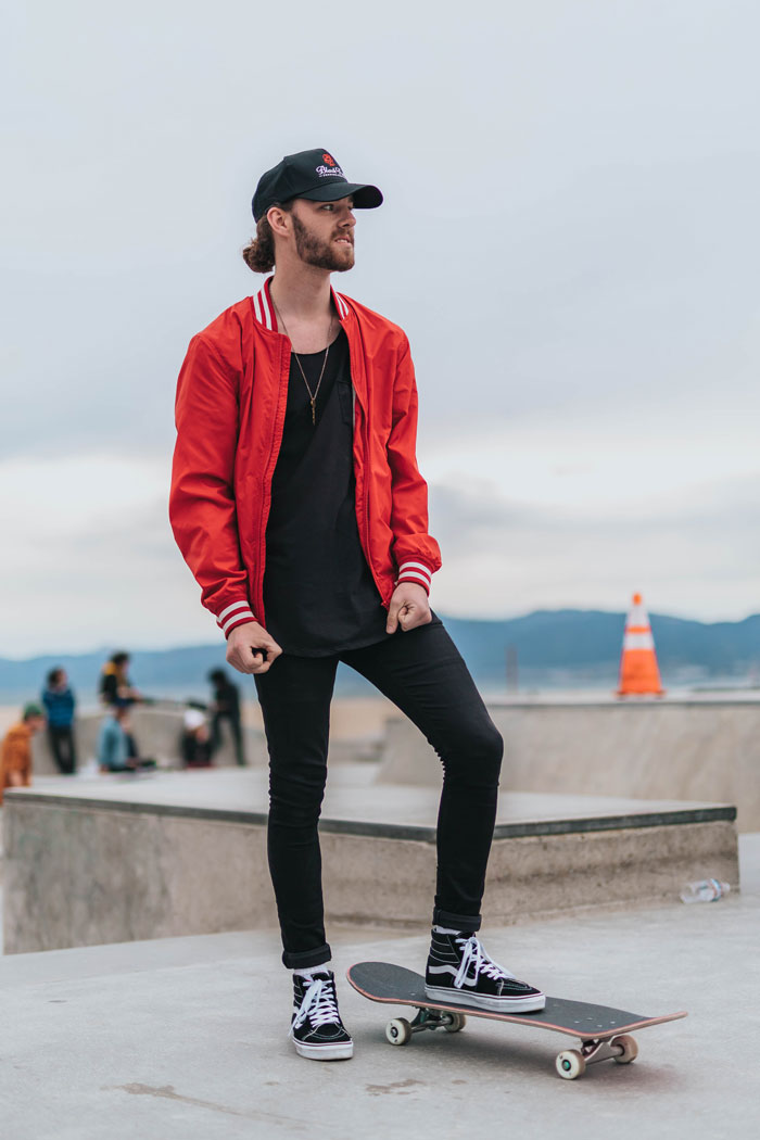 Man standing wearing red jacket with black shirt and black jeans