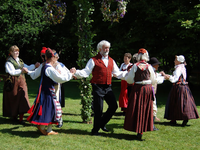 Persons wearing traditional clothes and celebrating Midsummer