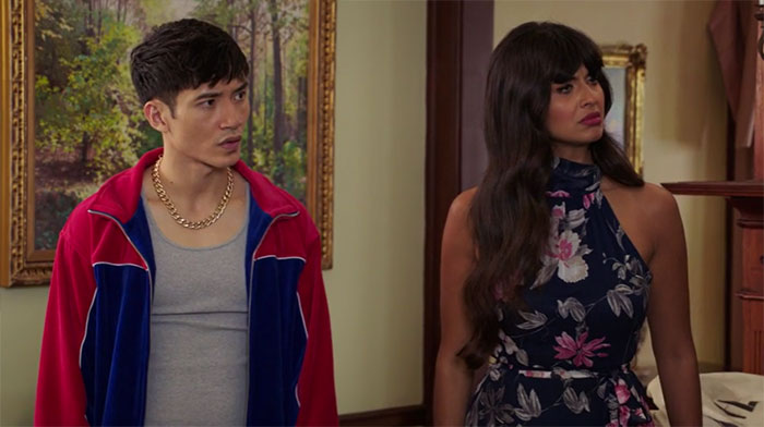 Jason wearing red and blue jacket, Tahani wearing black dress 