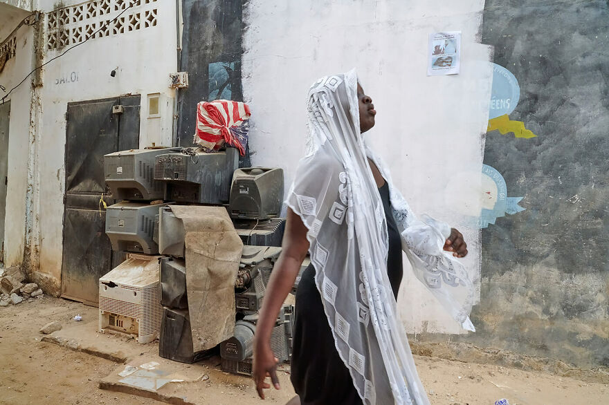 "A Young Woman Struts Through The Streets Of Ngor"