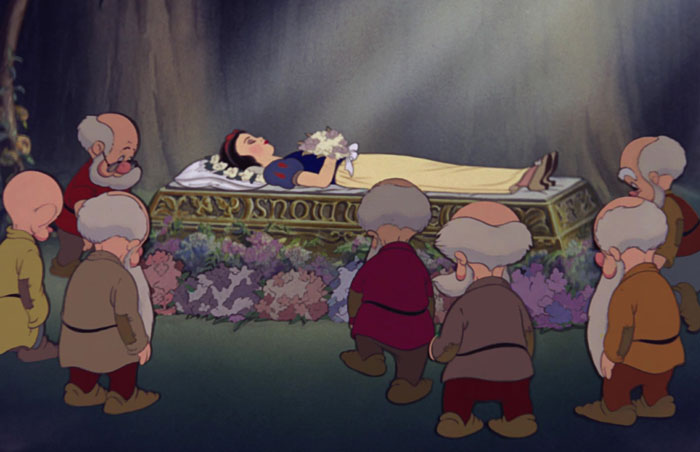 Snow White lying in the bed and dwarfs looking