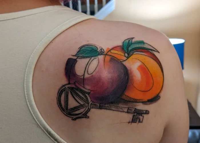A tattoo design featuring colorful peaches and a key, viewed by some as uncreative.