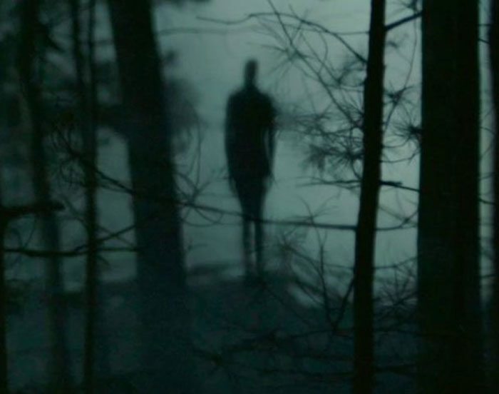 Slenderman standing in the dark forest 