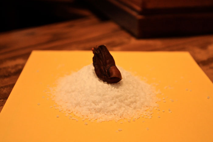 salt with a snack in the form of a human toe on a yellow paper napkin 