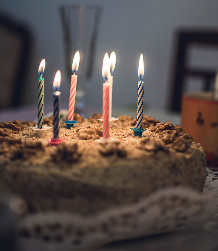 Multiple lit up candles on a cake 