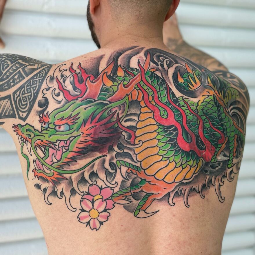 multicolored tattoo of a green dragon on the back