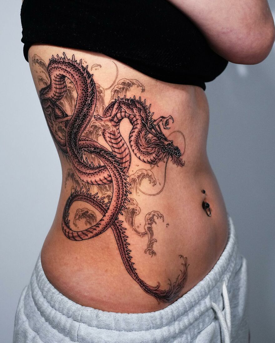 An image of a black ink dragon tattoo on obliques