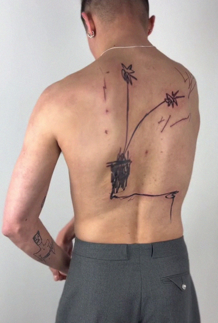 Viral tattoo with 2.5M views shows a man's back featuring a simplistic flower design, sparking mixed reactions. Viral tattoo with 2.5M views shows a man's back featuring a simplistic flower design, sparking mixed reactions.