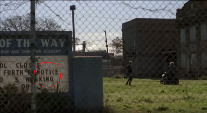 In True Detective S01 E03 When Rust First Meets The Yellow King, The Sign When Walking By Spells Out "Notice King."