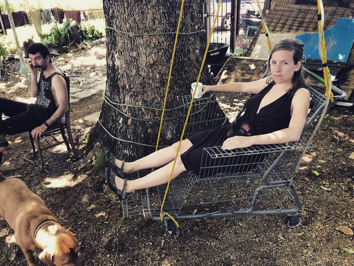 Woman sitting in the grocery trolley as a chair 