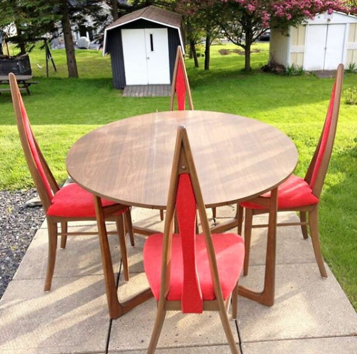 Red chairs with pointy backs around wooden table 