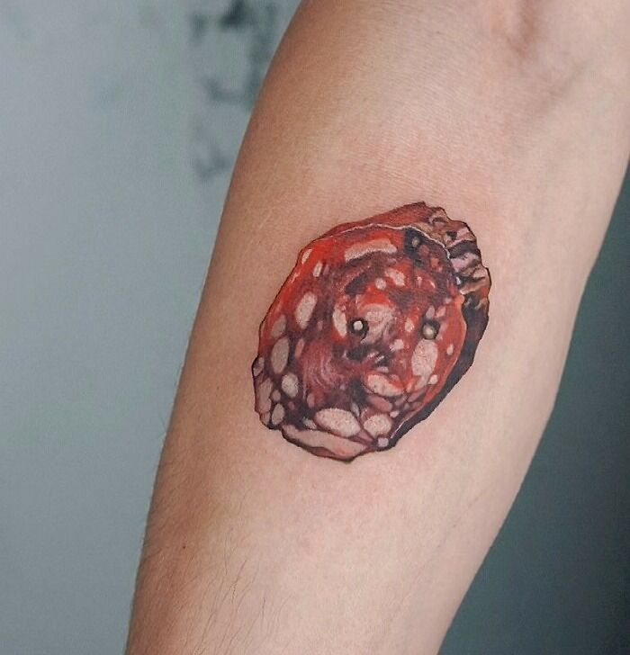 Watercolor minimalistic salami tattoo on forearm, showcasing creative food-inspired ink-spiration.