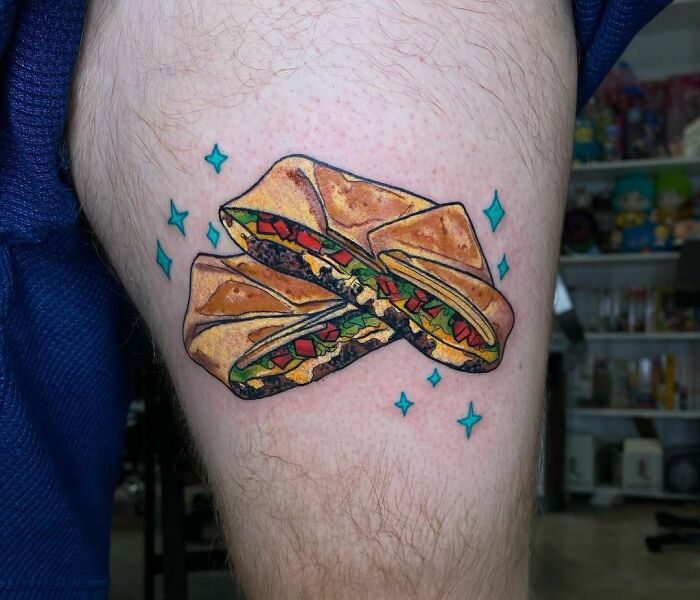 Watercolor food tattoo of a wrap with colorful fillings, featuring sparkling accents.