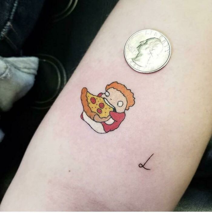 Pop culture tattoo of a character holding pizza near a coin for size comparison.