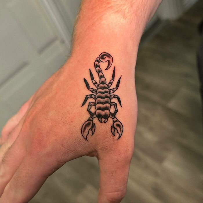 Black scorpion tattoo on hand