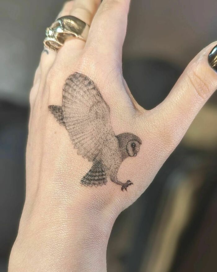 Realistic flying owl tattoo on hand