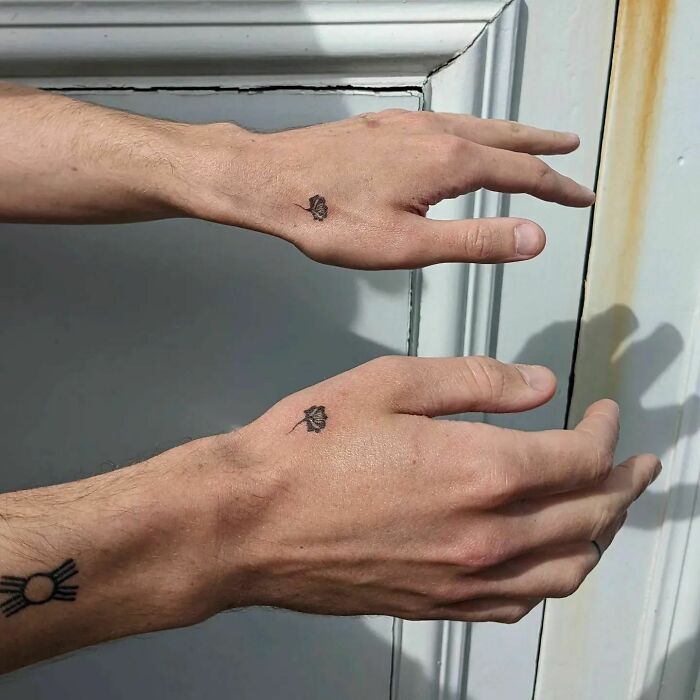Small black roses tattoos on hands