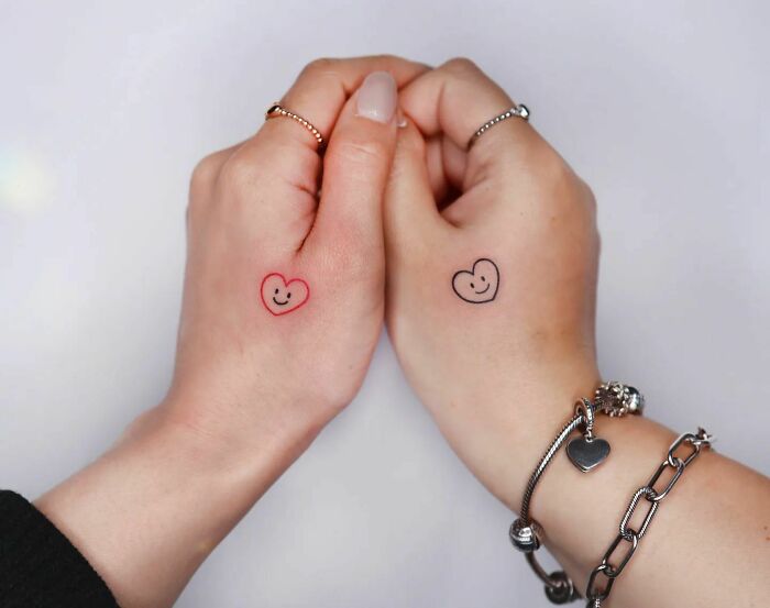 Two smiling hearts tattoos on hands