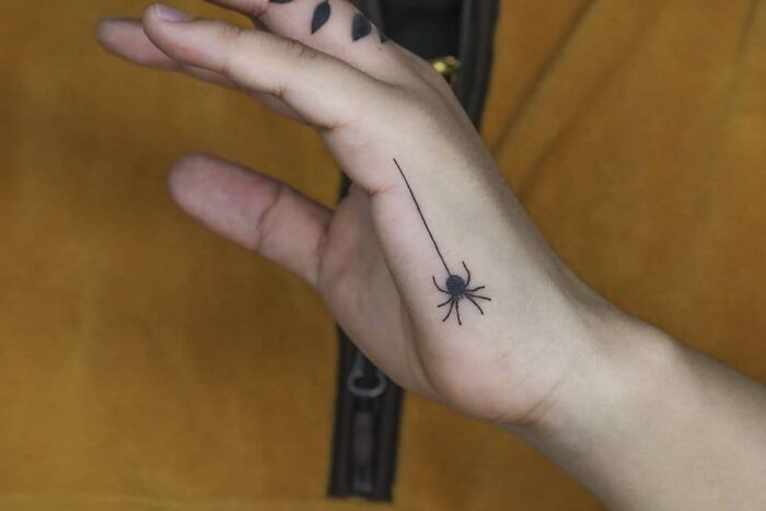 Black spider tattoo on hand