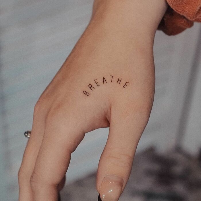‘Breathe’ lettering tattoo on hand