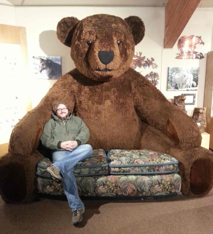 Man sitting on the big couch like a teddy bear 