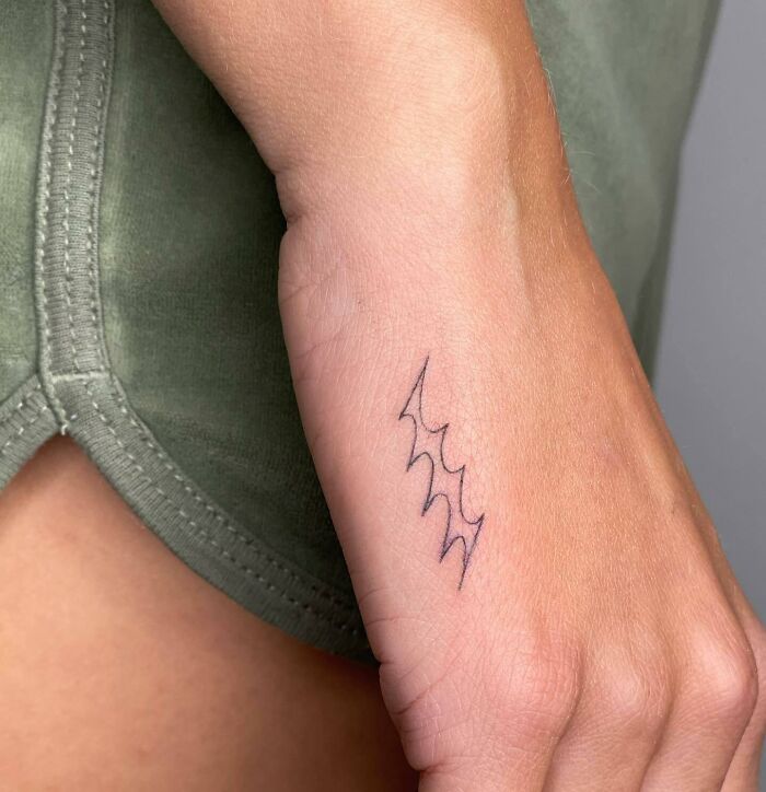 Small abstract lightning tattoo on hand