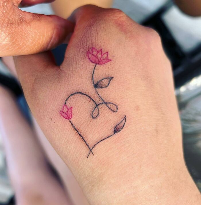 Pink flower and heart simple tattoo on hand