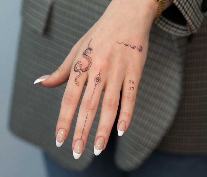 Delicate hand tattoos with snake, eye, line and numbers