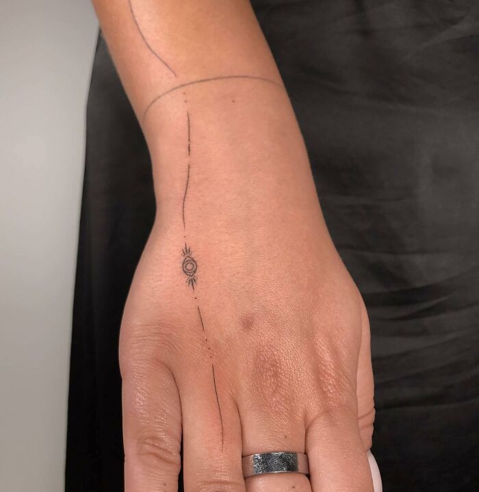 Simple eye and line tattoo on hand