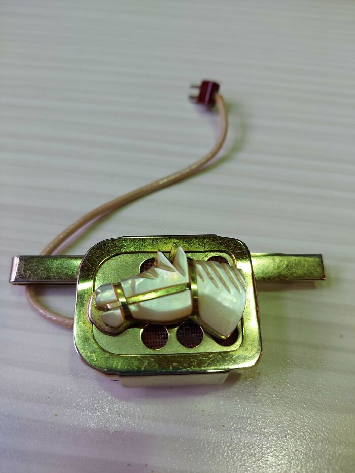 Found This In Our Donation Bin, We're A Nonprofit, We Recycle Eyeglasses And Hearing Aids. It's A Gold Plated Speaker With A Short Cord With 2 Prongs At The End, It Also Has A Gold Plated Clip With An Opal-Like Material Of A Horse On It