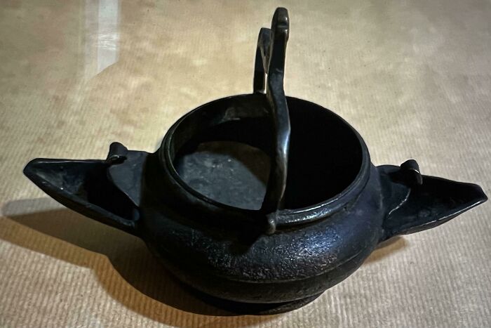 What Is This Ancient Bronze Pot With Two Spouts That Looks Like A Hanging Lavabo But Whose Necks Are Too Low To Carry Water Without Spilling?