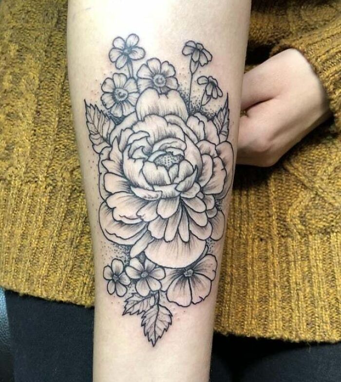 Elegant flower tattoo on forearm, showcasing intricate design and beauty.