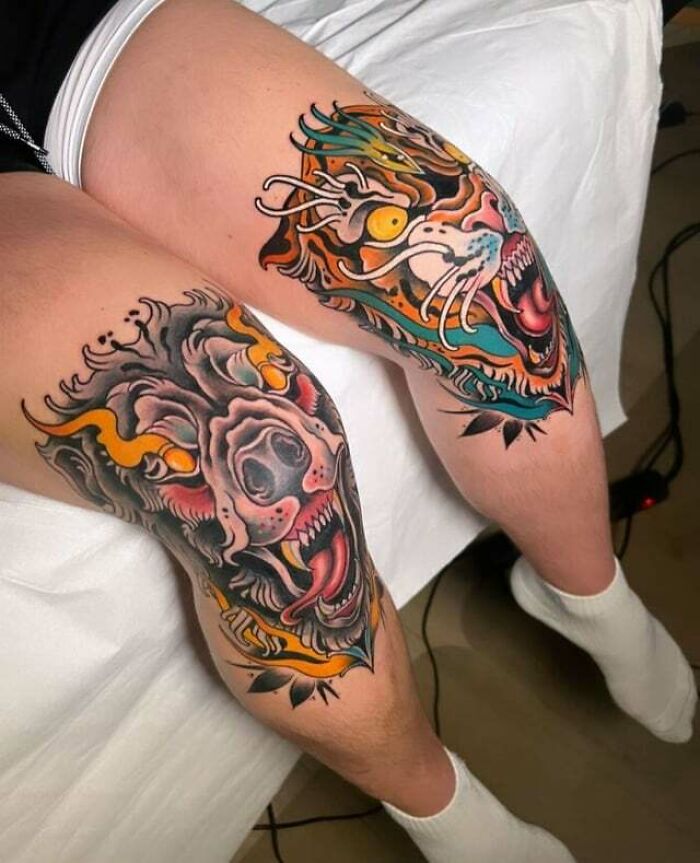 Colorful, intricate knee tattoos featuring a dragon and lion design on a person's legs.