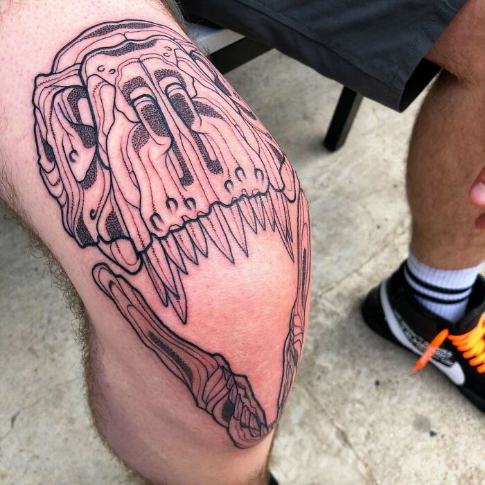 T-Rex skull around knee tattoo