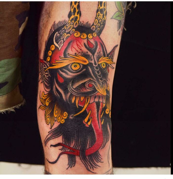 Devil head with yellow horns, eyes and eyebrows tattoo