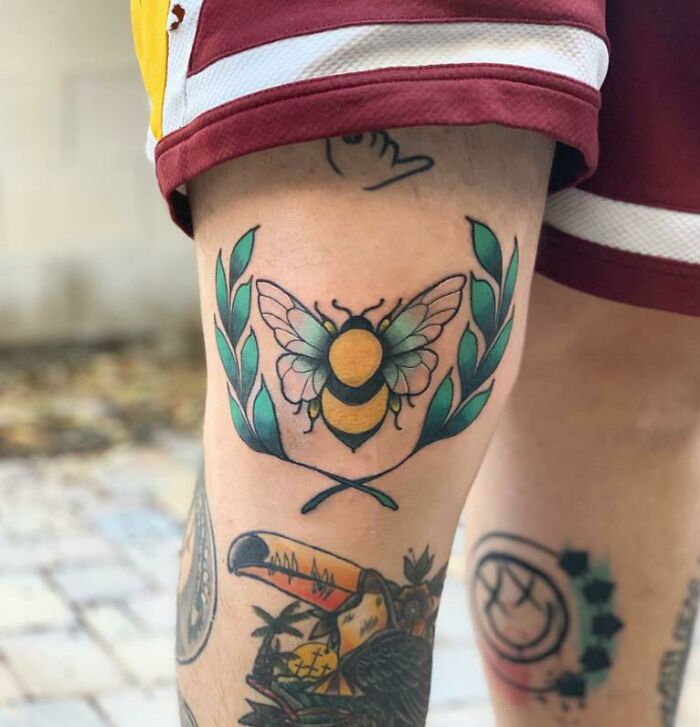 Bee and green leaves tattoo