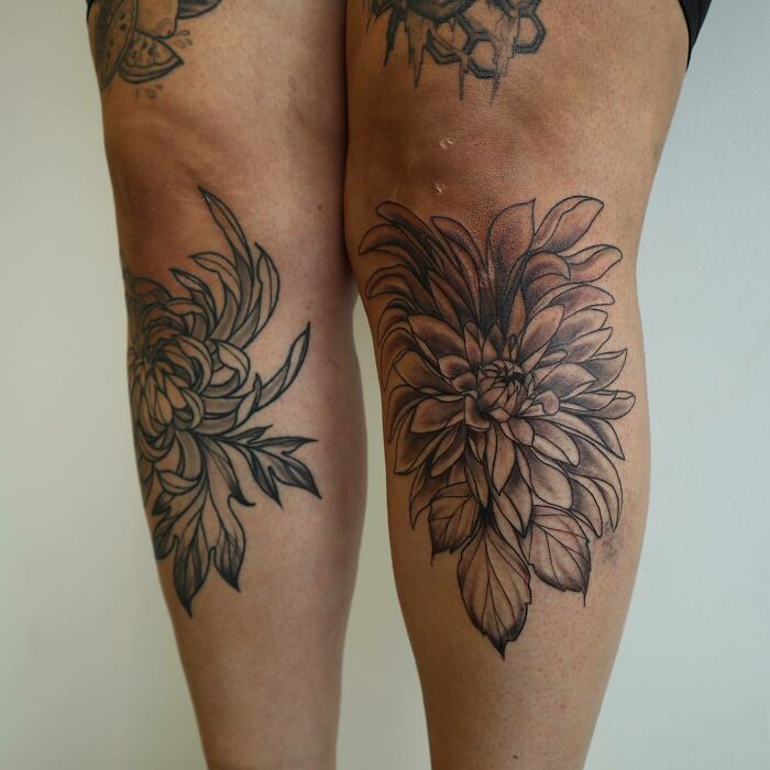 Floral knee tattoos featuring detailed black ink designs on both knees.
