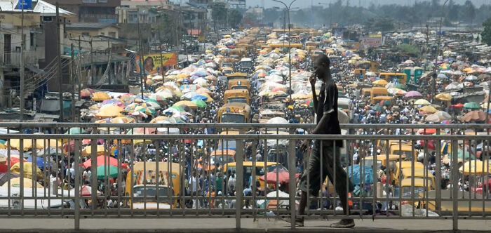 Man On Pedestrian Bridge Overlooking Traffic In Lagos, Nigeria. (Photo: Akintunde Akinleye)