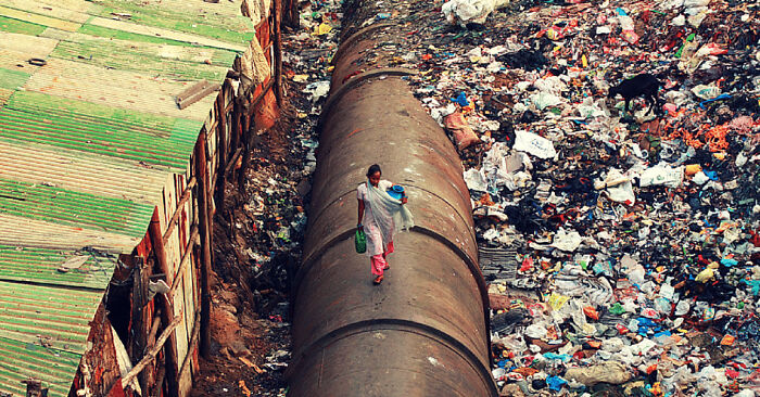 Tuberías de Mumbai llenas de basura pasando por un barrio de chabolas