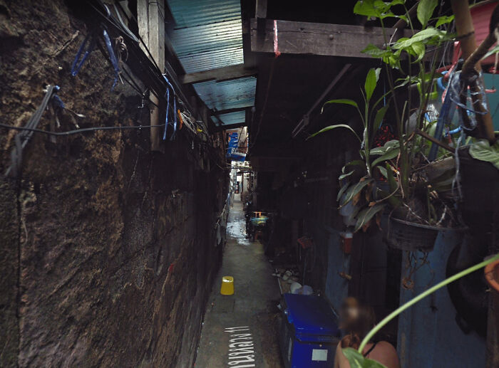 People Live In The Tiny Gap Between Commercial Buildings And The Official Residence Of Thailand's Prime Minister